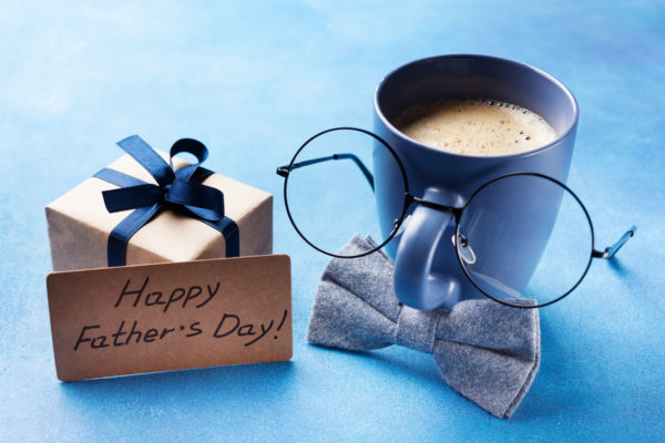 We see Father's Day Breakfast with a funny faced coffee mug, cute and close up. 